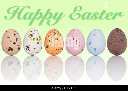 Sechs Candy beschichtete Schokoladeneier in einer Linie mit dem Text Frohe Ostern auf einem abgestuften Hintergrund. Stockfoto