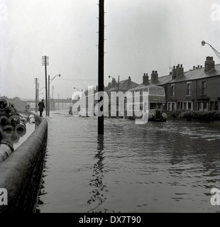 1950er Jahren überflutet historische Bild einer Straße in Manchester, England, mit einem Doppeldecker-Bus und Autos fahren durch das Wasser. Stockfoto