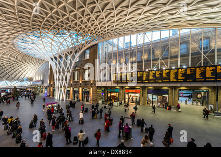 Zug-Abfahrtstafel und gewölbte Halle von britischen Architekten John McAslan & Partners am Bahnhof Kings Cross Railway, London Stockfoto