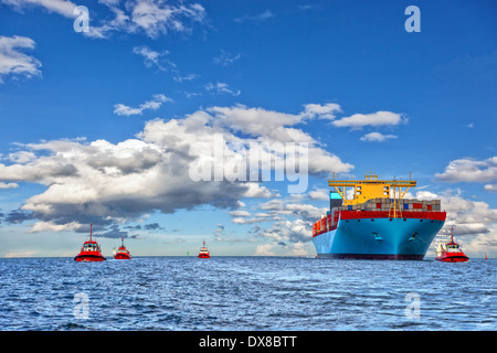 Schlepper Mitarbeitende Container Frachtschiff zum Hafen. Stockfoto