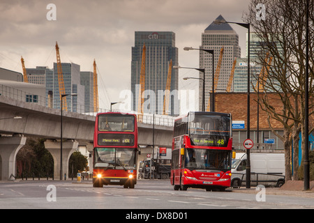 Roten Londoner Busse in East London mit Canary Wharf, dem Dom und dem DLR im Hintergrund. Stockfoto