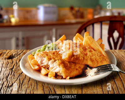 Traditionelle britische Zerschlagene Fish und Chips serviert auf einem Teller in einem traditionellen Küche Einstellung bereit zu essen Stockfoto