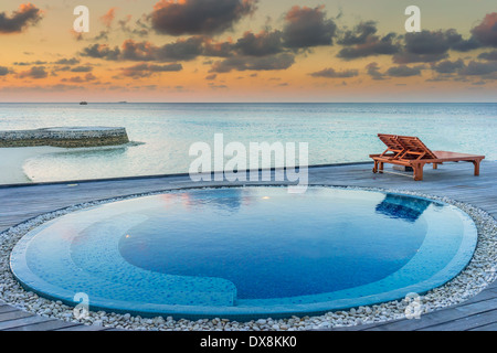 Kleiner Pool bei Sonnenuntergang in einem Luxus-Resort auf den Malediven Stockfoto