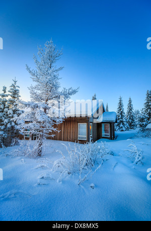 Blockhaus und Schnee bedeckt Bäume in der extremen Kälte, Lappland, Schweden Stockfoto