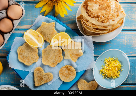 Verschiedenen geformten Zitrone Pfannkuchen auf einen blauen Teller Stockfoto