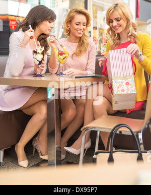 Junge fröhliche Freundinnen Fruchteis Essen Stockfoto