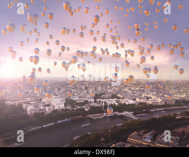 Viele bunte fliegende Luftballons mit der Stadt im Hintergrund Stockfoto