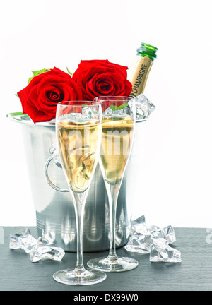 festliches Arrangement mit Sekt und Blumen. zwei Gläser, Flasche Champagner und rote Rosen Stockfoto