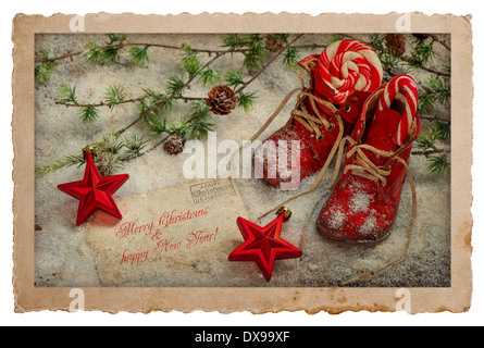 Vintage-Stil-Weihnachten-Postkarte. Retro-Urlaub Dekoration mit rot Baby Schuhe, Christbaumkugeln und Grüße Karte Stockfoto