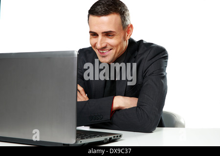 Glücklich Kaufmann mit Laptop auf einem weißen Hintergrund isoliert am Tisch sitzen Stockfoto