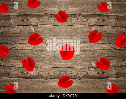 rote Rosenblätter in Herzform über rustikalen hölzernen Hintergrund. Valentinstag Hintergrund Stockfoto