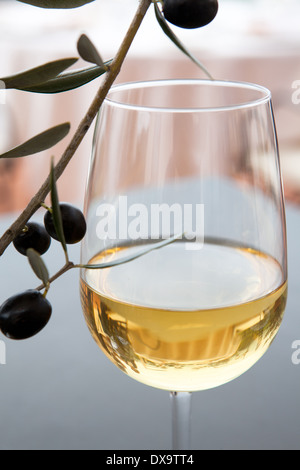 Glas Weißwein, Filiale von schwarzen Oliven, Rosmarin und Olivenblätter Stockfoto