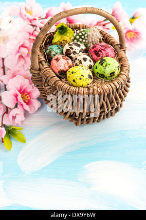 Oster-Deko mit Blumen und Eiern in Korb. Handgefertigte farbige Stockfoto
