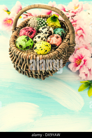 Oster-Deko mit Blumen und Eiern in Korb. Retro-Stil Bild Stockfoto