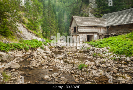 Holzhaus in den Bergen mit Creek und Rasen Stockfoto