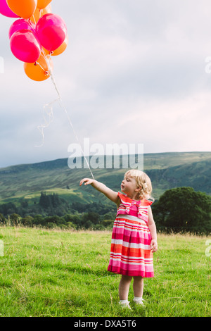 Geburtstagskind mit rot und orange Luftballons Stockfoto