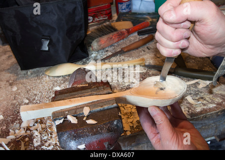 Löffel-Carver mit einem Gauner-Messer zum Schnitzen aus der Schale Stockfoto