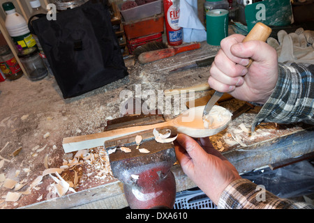 Löffel-Carver mit einem Gauner-Messer zum Schnitzen aus der Schale Stockfoto