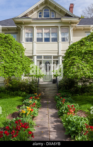 Schöne historische Haus mit einem schönen grünen Vorgarten im Frühjahr. Stockfoto