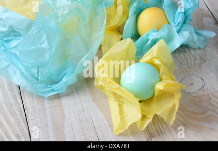 Erhöhte Ansicht Pastell Ostereier mit Seidenpapier umwickelt. Geringe Schärfentiefe mit Fokus auf dem vorderen Ei. Stockfoto