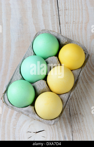 Hohen Winkel Schuss ein six-Pack von Ostern Eiern auf einem rustikalen Bauernhof Küchentisch. Hochformat. Stockfoto