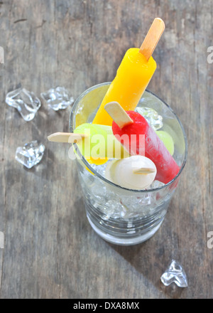 Fruchtige Popsicle Sticks in Glas auf alten hölzernen Hintergrund Stockfoto