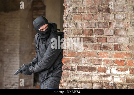 Mann mit Maske mit Pistole Stockfoto