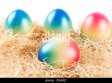 bunte Ostereier auf etwas Heu liegend Stockfoto