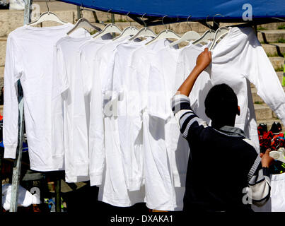 Jerusalem, Israel - 21. März 2014: A palästinensischen Jungen richtet seine Kleider stehen vor Damaskus-Tor. Viele Shop-Anbieter richten Sie Stände mit Essen oder Kleidung, wie Tausende von Palästinensern Kopf auf diese Weise nach Mittag Freitagsgebet in Al Aqsaq Mosque in der Altstadt von Jerusalem zurück.  (Foto von Anna Ferensowicz / Pacific Press) Stockfoto