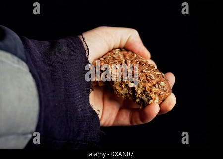 Mannes Hand hält ein Stück Brot, Stockfoto