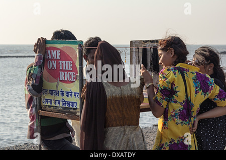 Freunde kaufen Geschenke und Souvenirs aus einem Straßenstand auf dem Weg zur Moschee Haji Ali Dargah Shariff in Mumbai, Indien Stockfoto