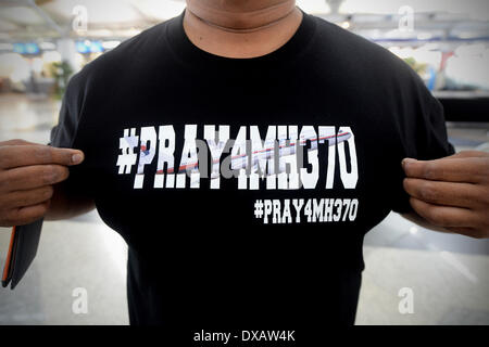 Kuala Lumpur, Malaysia. 22. März 2013. Ein nicht identifizierter malaysischer Mann hält seine Tshirt schmücken mit den besten Wünschen für die fehlenden Malaysia Airline, MH370 für die Kamera am Kuala Lumpur International Airport in Sepang, Stadtrand von Kuala Lumpur, Malaysia, Samstag, 22. März 2014. Australiens Premierminister sagte Suche Flugzeuge fliegen tief in den südlichen Indischen Ozean bisher nichts gefunden haben, die aus der fehlenden Malaysia Airlines Jet sein könnte, am Freitag. Die Flugzeuge gehören zu den internationalen Bemühungen zur Lösung des fast 2 Wochen alten Geheimnisses der passierte Flug 370 mit 239 Personen eine Stockfoto