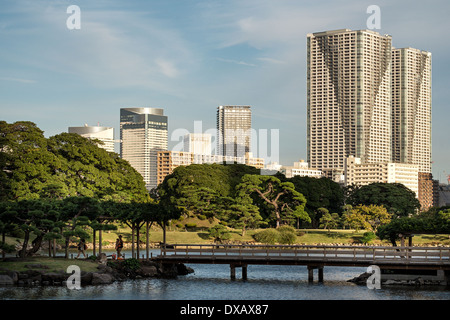 Brücke in Hama-Rikyu Garten mit Shiodome Wolkenkratzern im Hintergrund, Tokyo, Japan Stockfoto