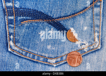 Münzen aus einem Loch in Jeans-Tasche herausfallen Stockfoto