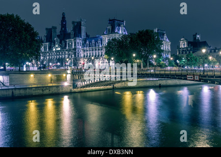 Eine nächtliche Aufnahme des Hotel de Ville über dem Fluss Seine. Stockfoto