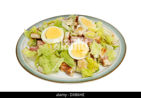 Caesarsalat mit Speck und hart gekochtes Ei auf einem Teller isoliert gegen weiß Stockfoto