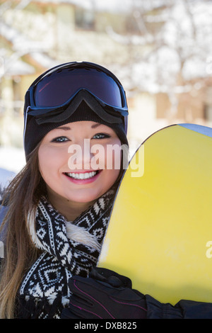 schöne junge Frau posiert im Freien mit ihrem Snowboard-Ausrüstung Stockfoto