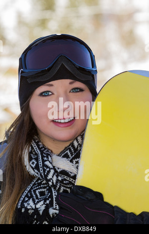 schöne junge Frau posiert im Freien mit ihrem Snowboard-Ausrüstung Stockfoto