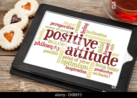 positive Einstellung Word cloud auf digitale Tablett mit einer Tasse Tee und Cookies Herz Stockfoto