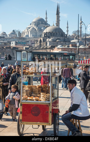 SIMIT Brot Anbieter auf dem Kai in Eminönü von Galata-Brücke, mit der Süleymaniye & Yeni Moschee im Hintergrund. Istanbul, Türkei. Stockfoto