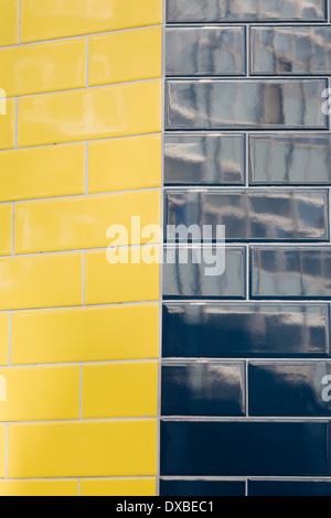 Geflieste gelbe und schwarze Wand Stockfoto