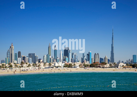 Jumeirah Open Beach mit Touristen und die Skyline der Wolkenkratzer in Dubai Vereinigte Arabische Emirate Stockfoto