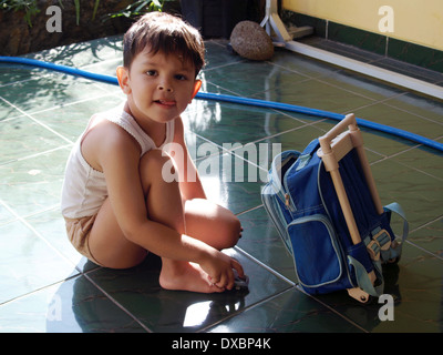 ein kleiner Junge ist vertieft im Spiel mit seinem Spielzeugauto außerhalb seines Hauses im kleinen Dorf Java Indonesien Stockfoto