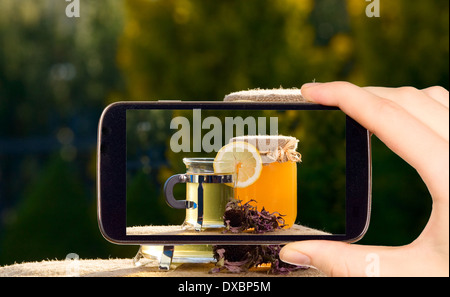 Mann nimmt Foto von Glas mit Honig mit smart Handy Stockfoto