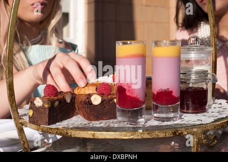 junge Frauen genießen einen Cream Tea an einem warmen sonnigen Nachmittag Stockfoto