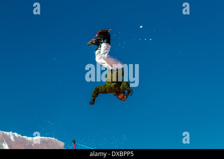 In der Luft Snowboarder über den Boden in einem Haufen auf einem riesigen airbag Stockfoto