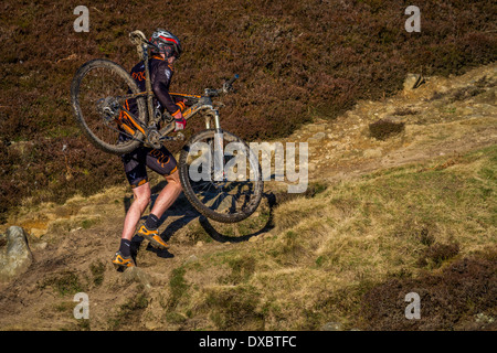 Biker sein Fahrrad eine steile Hügel in der Landschaft Stockfoto