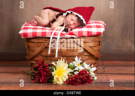 Neugeborenes Babymädchen in einem Little Red Riding Hood-Kostüm Stockfoto