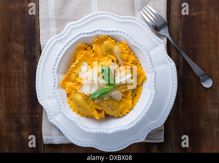 Butternut-Kürbis Mezzaluna Ravioli oder Tortellini in einer Schüssel auf rustikalen Holz Stockfoto