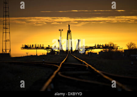 Die Sonne geht hinter die Sojus-Startrampe, kurz bevor das Raumschiff Sojus TMA - 12M mit dem Zug auf der Startrampe in Baikonur Kosmodrom 23. März 2014 in Baikonur, Kasachstan ausgerollt ist. Start der Sojus-Rakete ist geplant für März 26 und schicken Expedition 39 Sojus Kommandant Alexander Skworzow der russischen Federal Space Agency, Astronaut Steven Swanson der NASA, Kosmonaut Oleg Artemyev von Roskosmos auf einer sechsmonatigen Mission an Bord der internationalen Raumstation ISS. Stockfoto